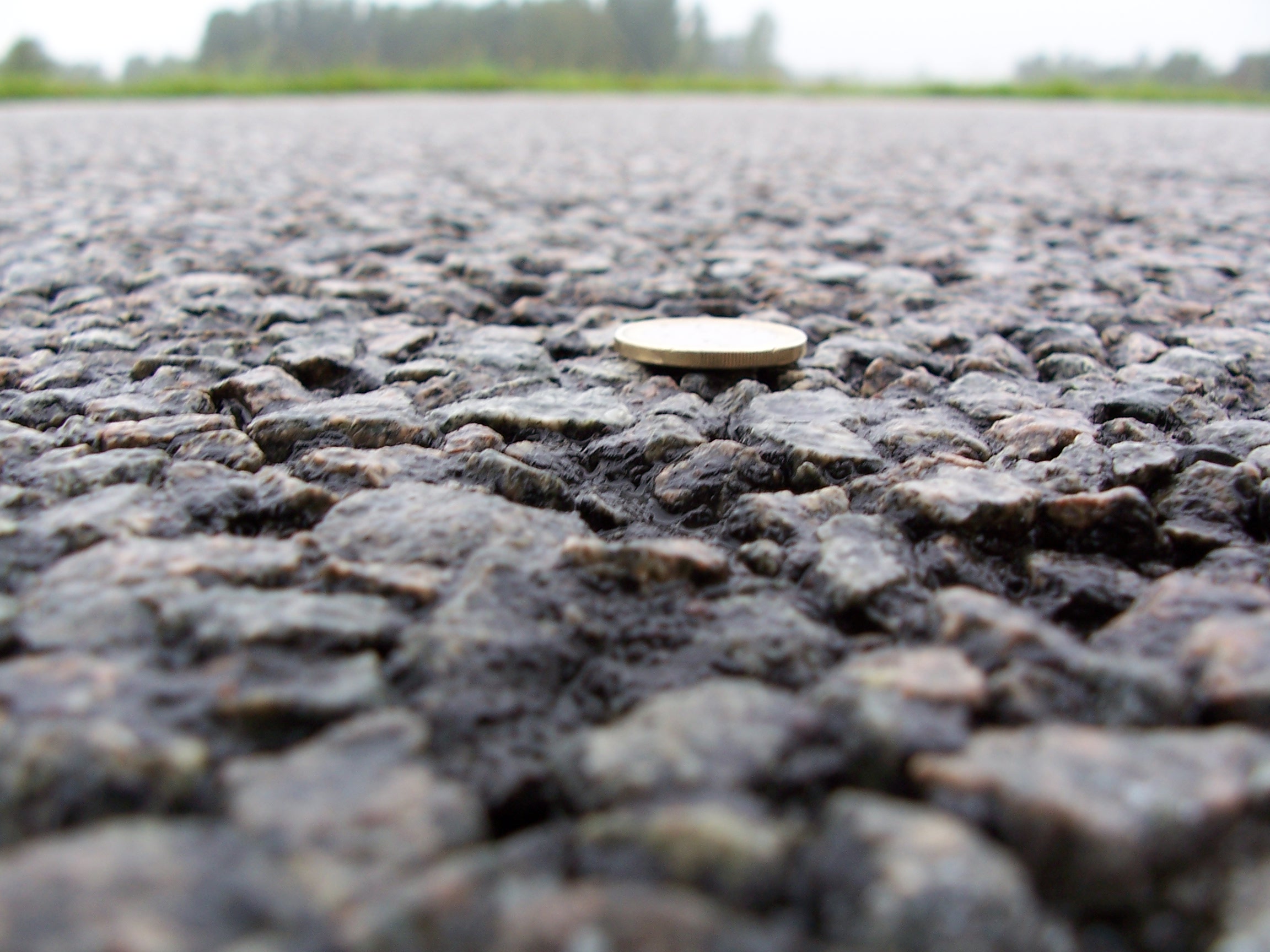 Texture on asphalt pavement with coin